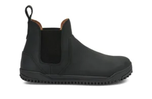 A black slip-on Chelsea Boot by Xero Shoes with elastic side panels, a pull tab at the back, rounded toe, and textured rubber sole. This simple design features visible stitching and a low heel—perfect for everyday styles.